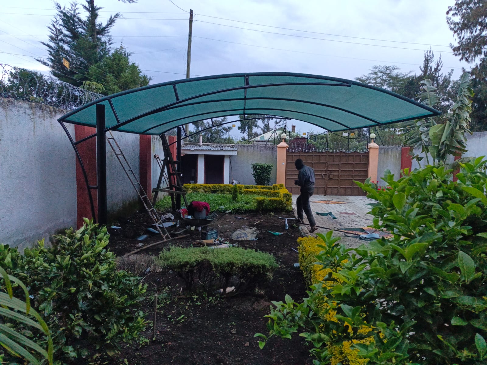 Green arched car parking shade installed at a residential compound